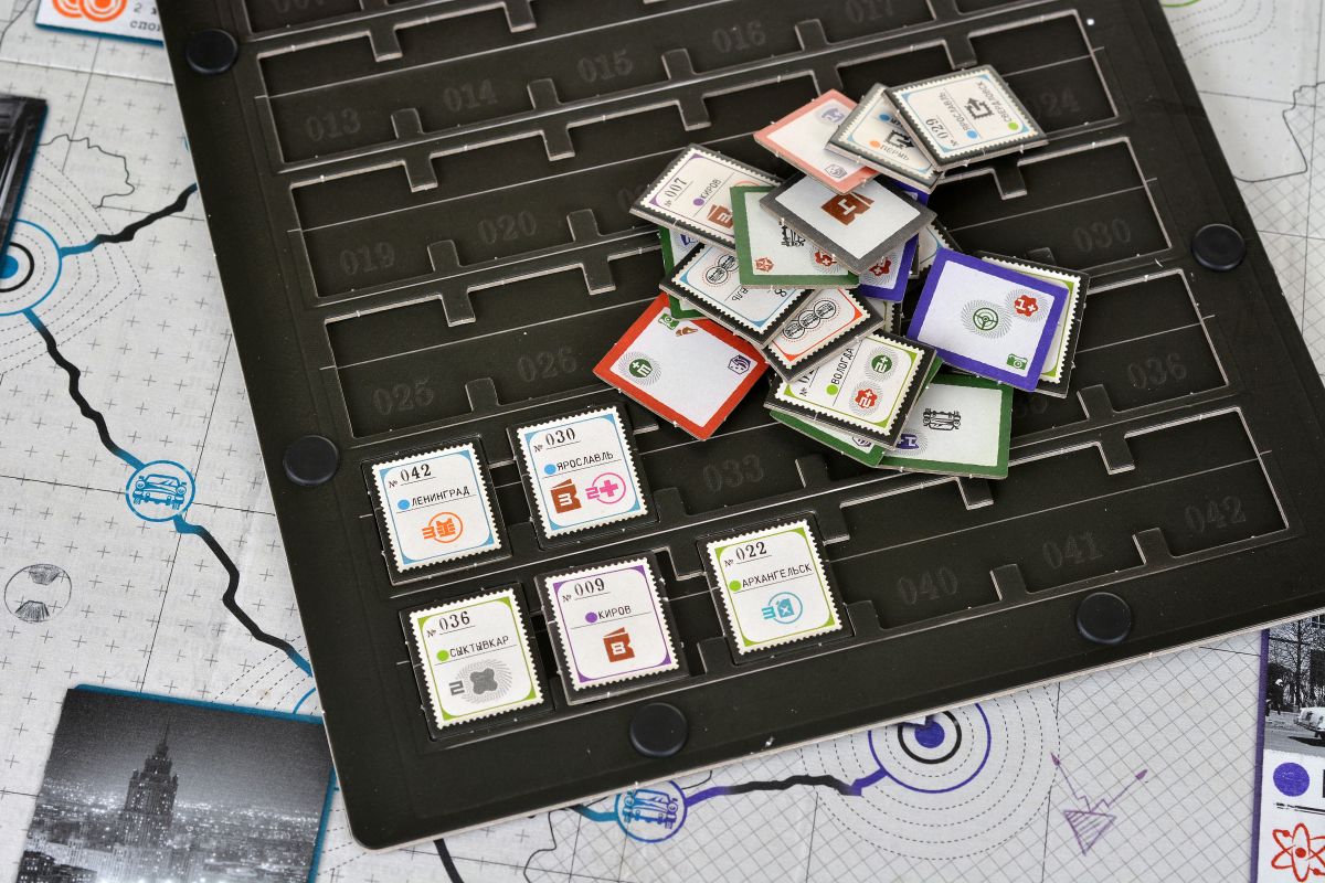 Это фишки заданий, которые нужно ставить на города, в которых они происходят. Если их перевернуть — они станут фишками союзников, дающих преимущества при игре.

Источник: Hobby World